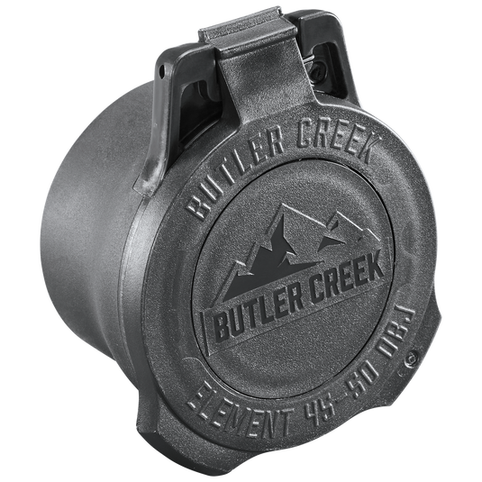 The Element Scope Caps - Objective is a black, round plastic flip-top cap with "BUTLER CREEK" and "ELEMENT 44-50 OBJ" plus a mountain graphic embossed on the lid, offering reliable lens protection.