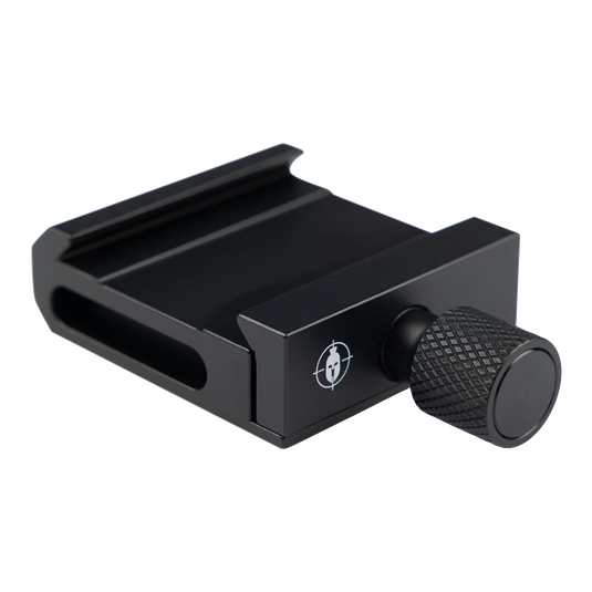 Primos MagnaSwitch Arca Adapter camera plate with a textured adjustment knob on a light gray background.